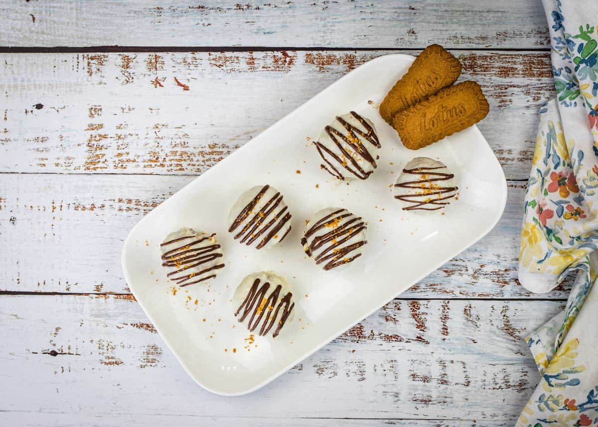 Six Biscoff Cookie Butter Cake Balls arranged on a black slate serving tray.