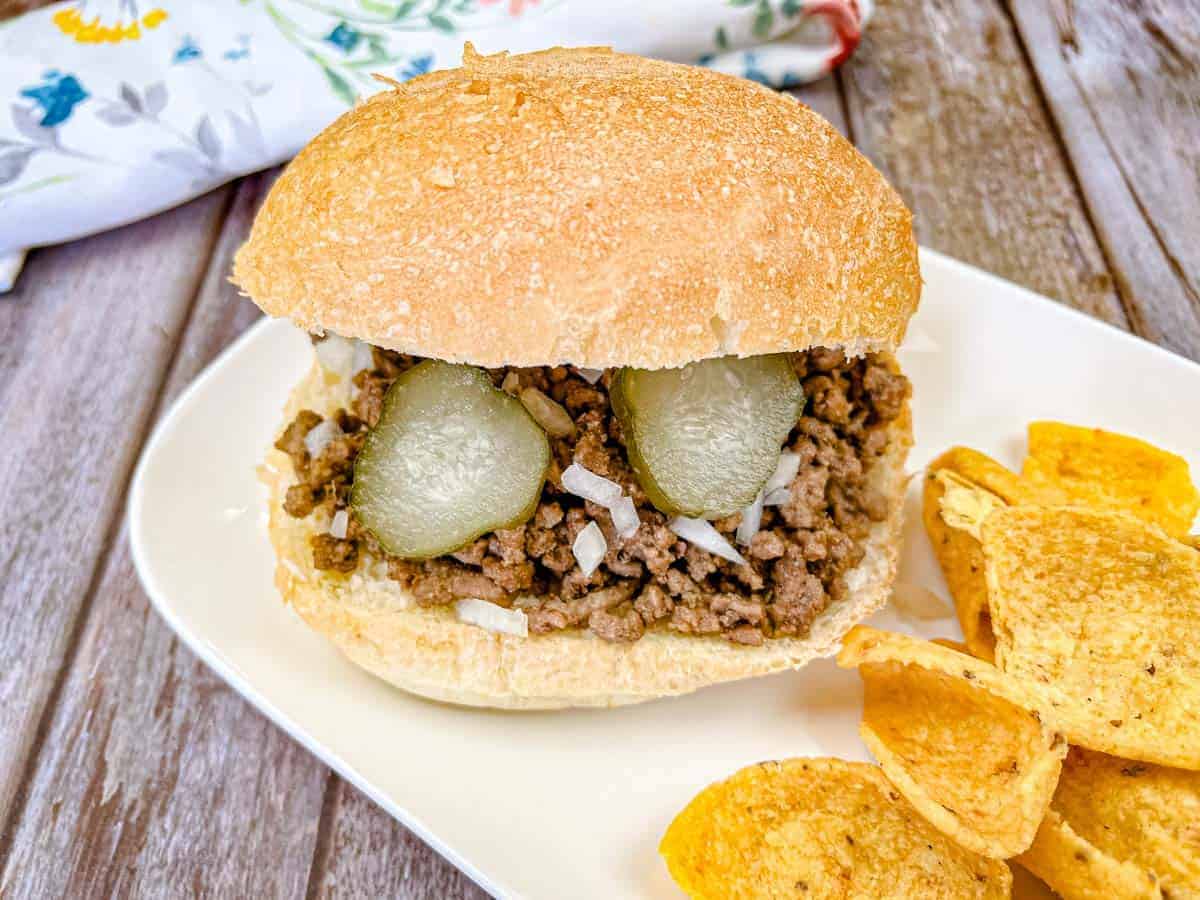 Copycat Maid-Rite Loose Meat Sandwich on a white plate with chips.