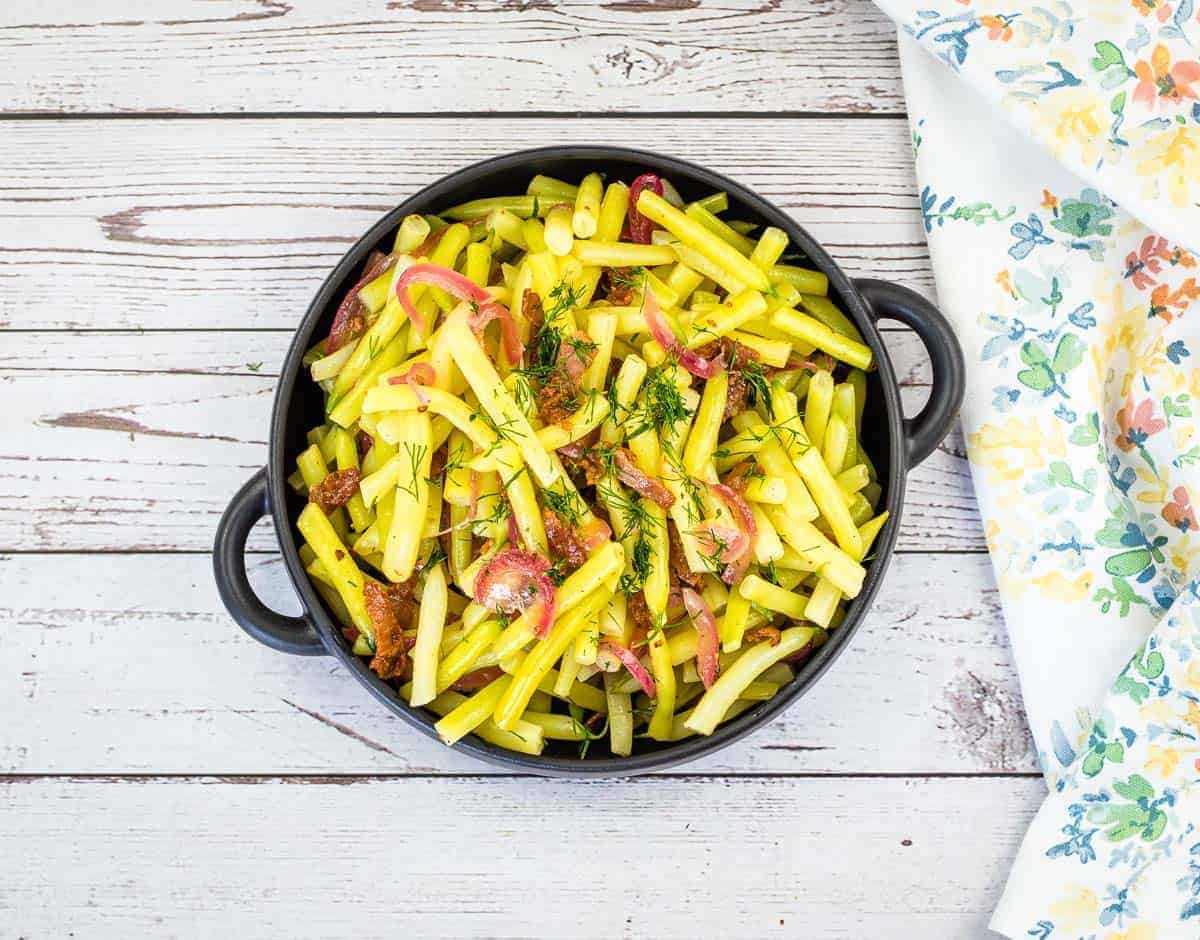 A bowl of German yellow beans on a wooden table.