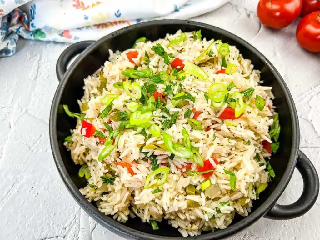 Mediterranean Rice in a black bowl on concrete.