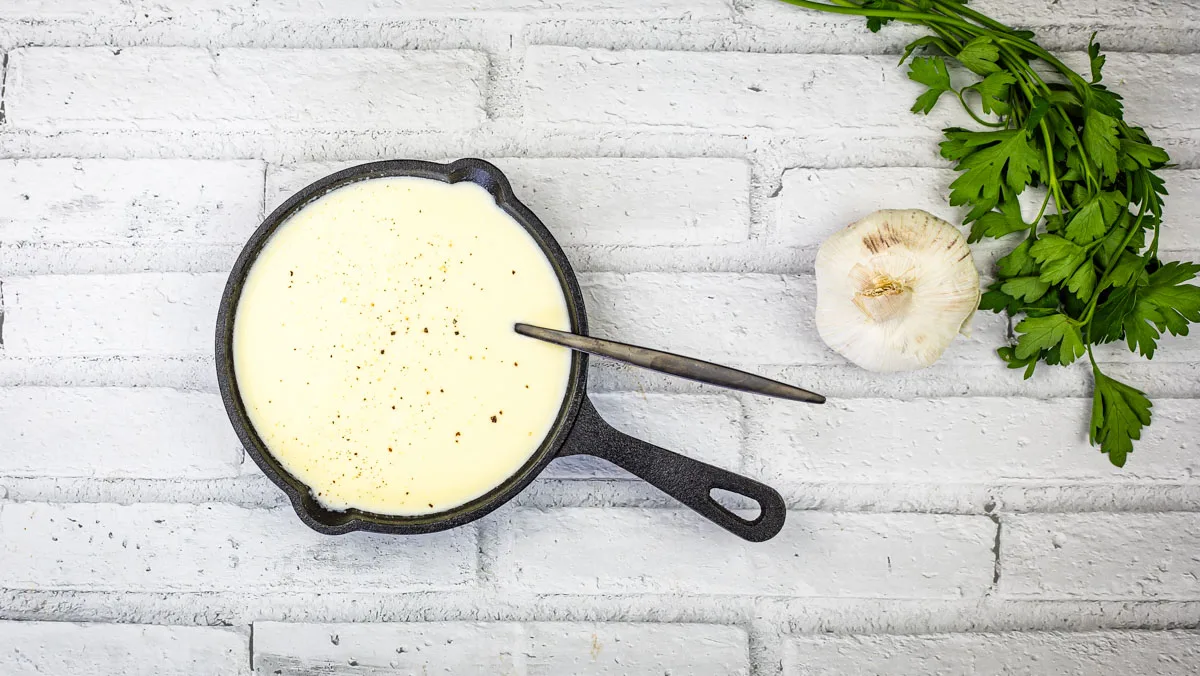 Copycat Olive Garden Alfredo Sauce in a black skillet.