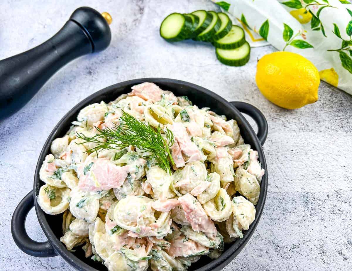 Salmon pasta salad in a black dish.