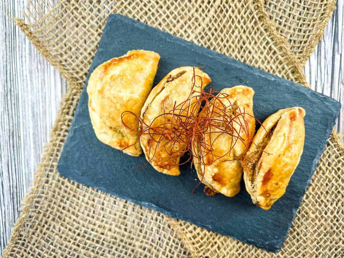 A plate of empanadas on a slate.