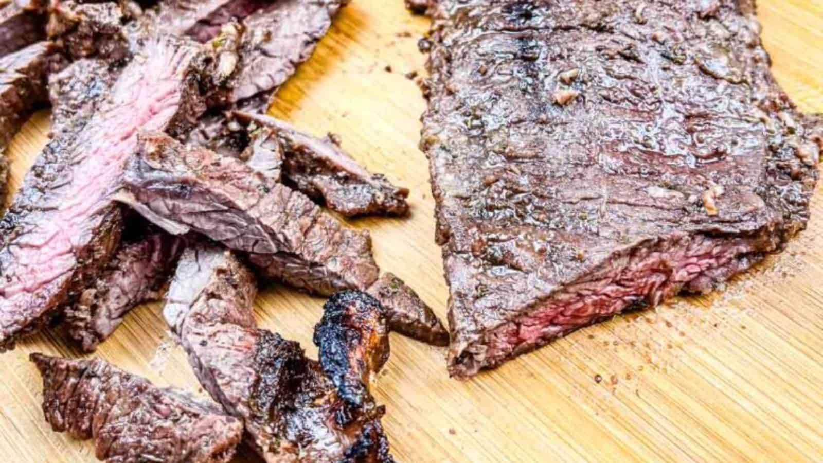 A sliced and grilled Carne asada on a wooden cutting board.