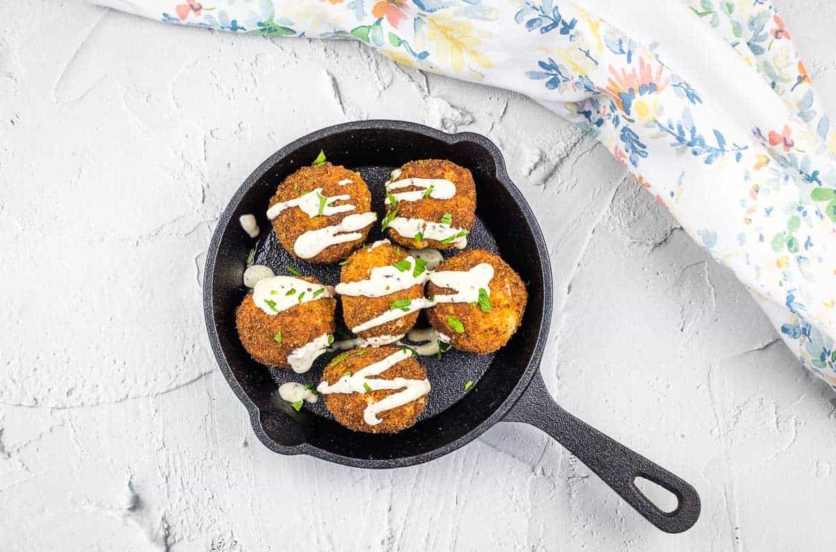 Sauerkraut Balls in a skillet on a white background.