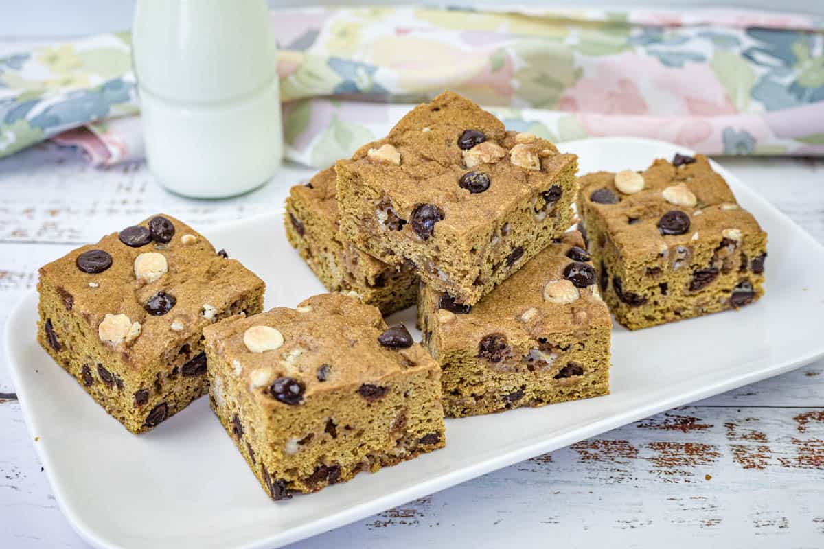 A white rectangular plate with pieces of pumpkin blondies.