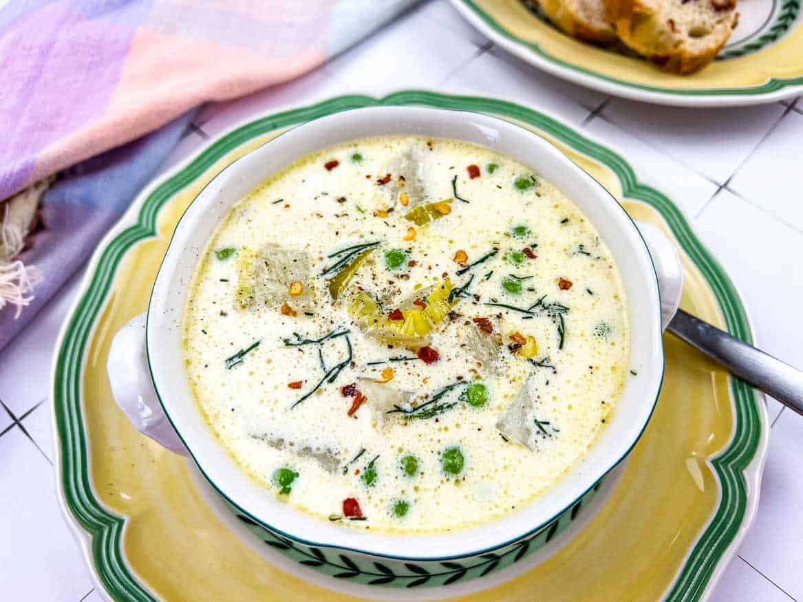 A closeup of a bowl of Potato & Green Pea Chowder.