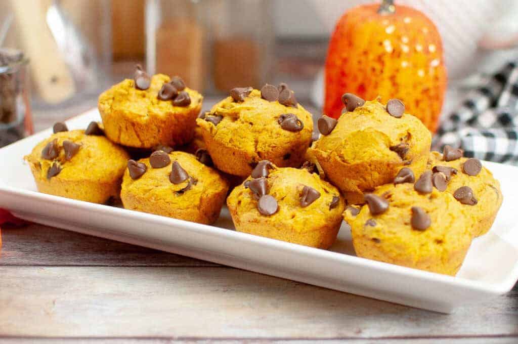 A white rectangular plate Cake Mix Pumpkin Spice Muffin topped with chocolate chips.