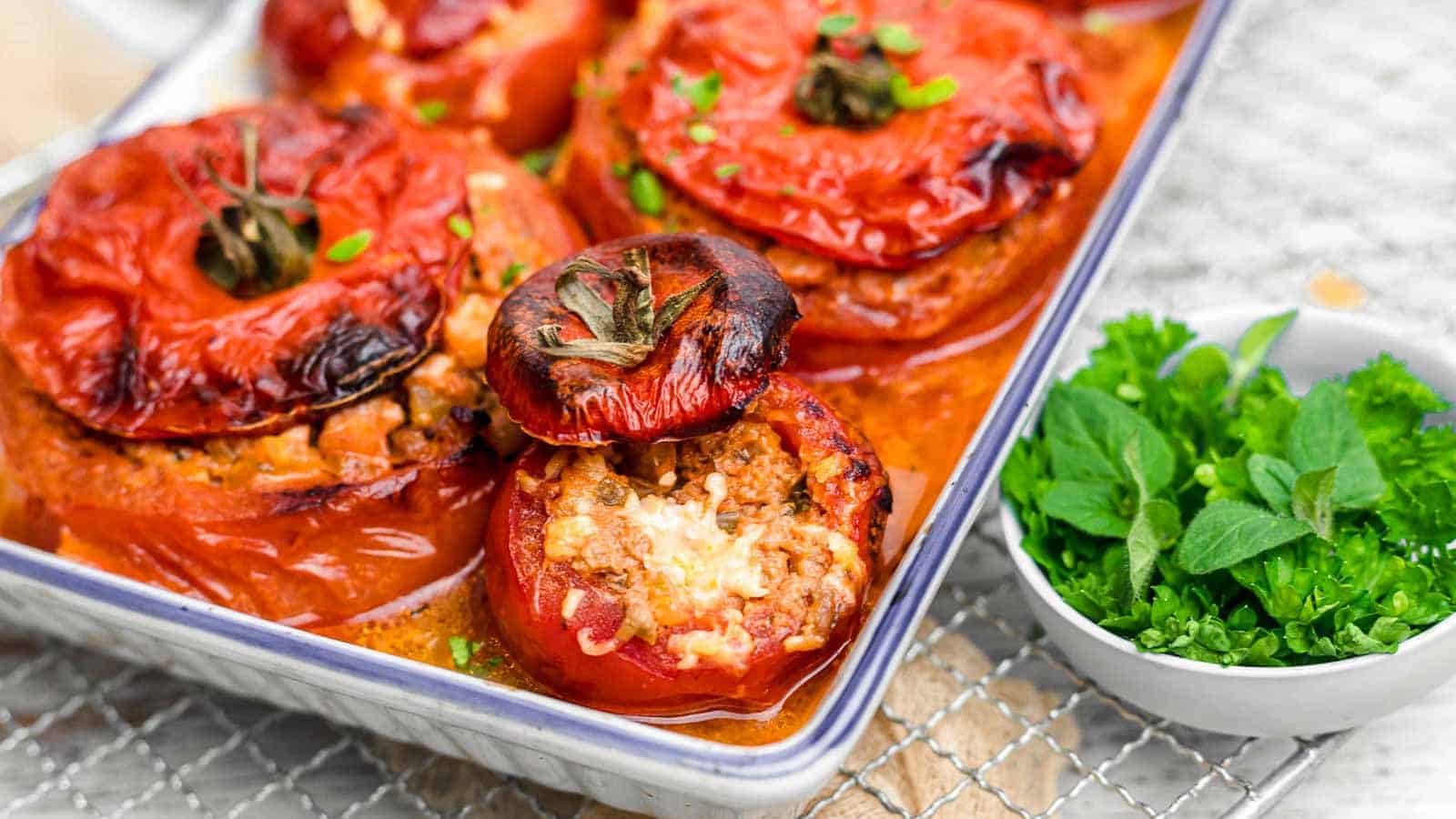 Stuffed Tomatoes inside white casserole.