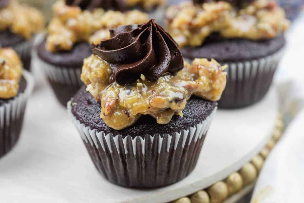 Close-up of German chocolate cupcake topped with coconut-pecan caramel and a swirl of chocolate buttercream.